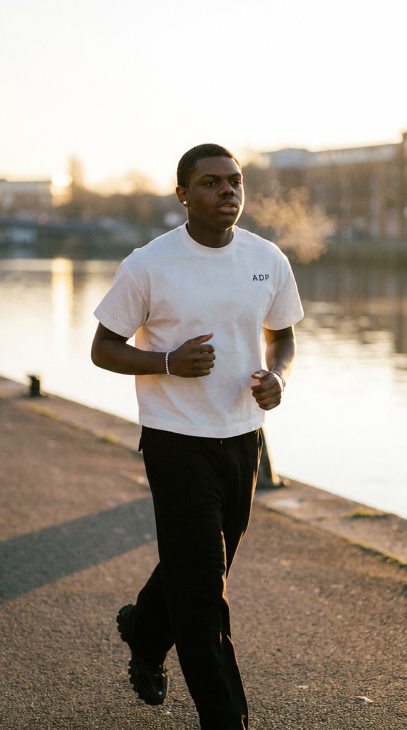 A model running along a waterfront at sunrise